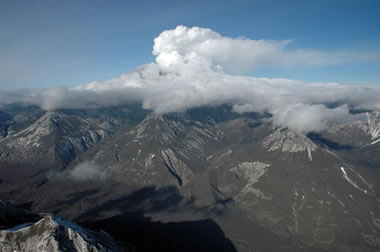 Redoubt in eruption with ash-covered landscape